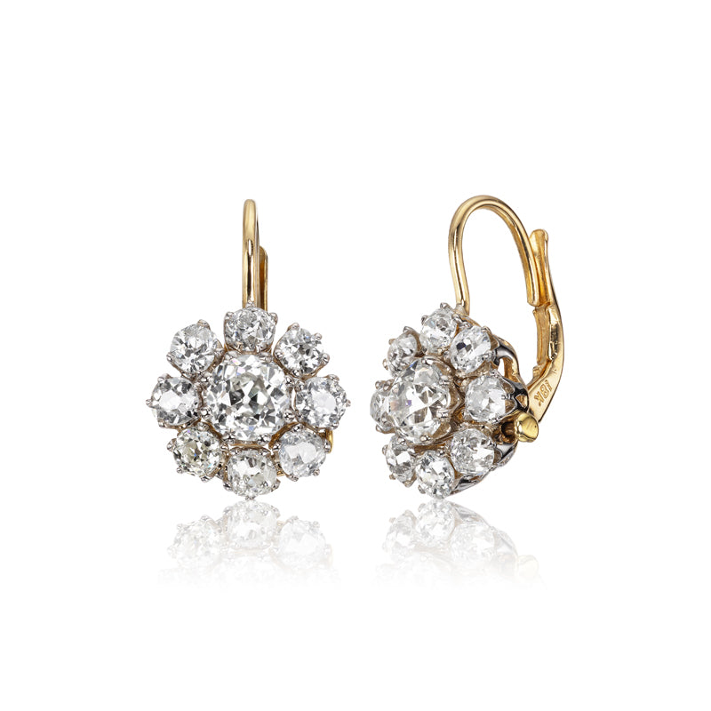 The Estelle 1.29 earrings are vintage gold pieces with a floral design, featuring clusters of sparkling white diamonds in a flower shape, shown on a white background.