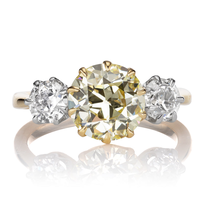 The PENDING Marielle 2.34 features a large round yellow diamond center stone flanked by two smaller round white diamonds, set on a two-tone gold and silver band.