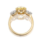 The PENDING Marielle 2.34 features a gold ring with a yellow center gemstone in a crown-like setting, flanked by two small white gemstones in silver-toned prongs, shown from the side.