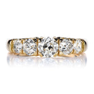 A five-stone diamond ring with old European cut diamonds set in a yellow gold band.